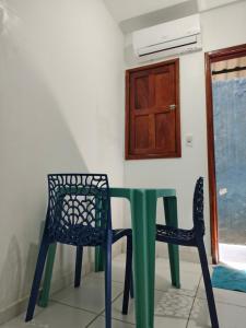 a green table and two chairs in a room at suíte feliz in Belém