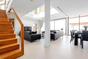 a living room with a staircase and a dining room at Cape Sienna Villa 4-Oceanfront 5-Bedroom Luxury Villa with 22 m Infinity Pool in Kamala Beach