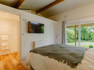 Un dormitorio con una cama y un televisor en la pared. en 1 Bed in Looe 88434, en Lanreath