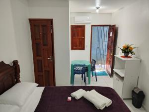 a bedroom with a bed and a table and a door at suíte feliz in Belém