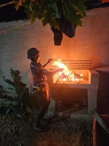 a man standing next to a fire in a grill at Morena villa in Kendwa +16 photos