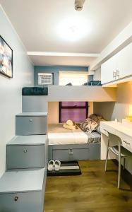 Habitación pequeña con litera y escritorio. en Urban Stay with Netflix KTV Wifi and Gym Park, en Manila