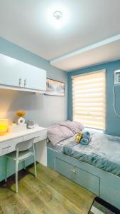 Un dormitorio con un escritorio y una cama y un escritorio y un mostrador. en Urban Stay with Netflix KTV Wifi and Gym Park, en Manila