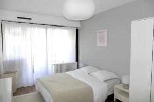 a white bedroom with a bed and a window at M007-8-9 Marquer Chambre colocation proche de la Gare in Annemasse