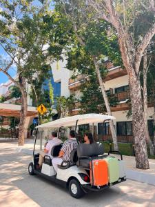a group of people riding in a golf cart at Hotel Mundo Maya Tulum Aeropuerto in Tulum
