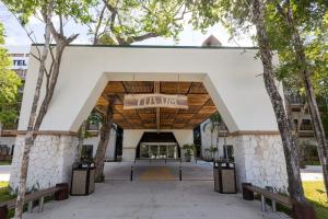 an entrance to a building with trees at Hotel Mundo Maya Tulum Aeropuerto in Tulum