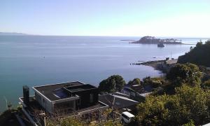 a house on the shore of a body of water at Beach side Apartment Nelson in Nelson