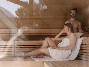 a man and a woman sitting in a sauna at MYALPS Tirol inklusive Sky- Wellness in Oetz