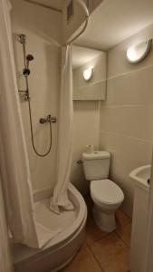 a bathroom with a toilet and a shower with a shower curtain at kawalerka w centrum Grajewa in Grajewo