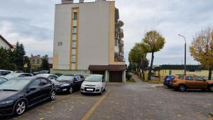 a parking lot with cars parked in front of a building at kawalerka w centrum Grajewa in Grajewo