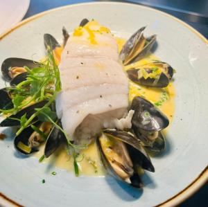 a plate of food with fish and mussels at Suite 12 - Sleeping Giant Hotel - Pen Y Cae Inn in Brecon +43 photos