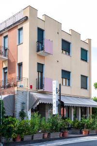 a building with plants in front of a street at Hotel Rivamare in Venice-Lido