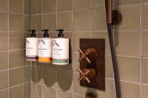 a bathroom with three shampoo bottles on a wall at Mollie's Manchester in Manchester