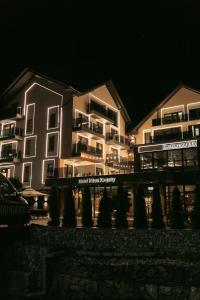 a lit up building at night with trees in front at Ribas Karpaty in Bukovel