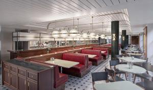 a dining room with red chairs and tables in a restaurant at Mollie's Manchester in Manchester
