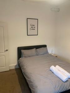 プラムステッドにあるModern one bed heart of Greenwichのベッドルームにタオル2枚が付いたベッド1台