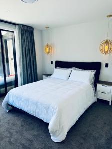 ein Schlafzimmer mit einem großen weißen Bett und einem Fenster in der Unterkunft 3Bedroom 2Bathroom Golf Skiing Hiking Lake Mountains 7 Min To Airport in Queenstown + 37 Fotos