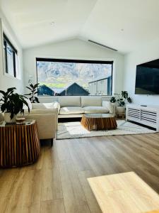 ein Wohnzimmer mit Couch und großem Fenster in der Unterkunft 3Bedroom 2Bathroom Golf Skiing Hiking Lake Mountains 7 Min To Airport in Queenstown