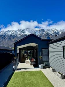 ein blaues Haus mit Bergen im Hintergrund in der Unterkunft 3Bedroom 2Bathroom Golf Skiing Hiking Lake Mountains 7 Min To Airport in Queenstown