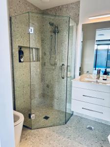 ein Badezimmer mit einer Glasdusche mit Waschbecken in der Unterkunft 3Bedroom 2Bathroom Golf Skiing Hiking Lake Mountains 7 Min To Airport in Queenstown