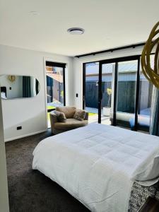 ein Schlafzimmer mit einem Bett und einer Couch und Fenstern in der Unterkunft 3Bedroom 2Bathroom Golf Skiing Hiking Lake Mountains 7 Min To Airport in Queenstown