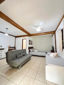 a living room with a couch and a table at Pousada Aimê Maresias in São Sebastião