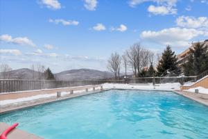 a swimming pool with snow on the sides of it at Notchbrook 28AB in Stowe