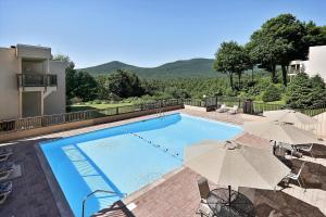 a swimming pool with two umbrellas at Notchbrook 28AB in Stowe
