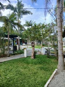 a yard with palm trees and a fence at Pousada Costeira Barra do Sul in Balneario Barra do Sul +4 photos
