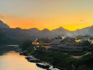 Una vista de un resort en el río al atardecer. en Sabaidee Nam Ou River View, en Nongkhiaw