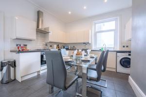 a kitchen with a table and chairs in a kitchen at The Lytham Retreat - New! Spacious & Luxurious in Lytham St Annes