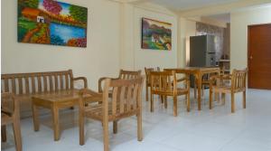 a dining room with wooden tables and chairs and a refrigerator at hotel casa martin in Gaira