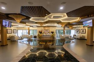a lobby with couches and a television in a building at Hotel Mundo Maya Tulum Aeropuerto in Tulum
