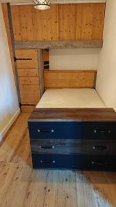 a bedroom with a bed and wooden walls and wooden floors at Maison Brunet in Aime La Plagne