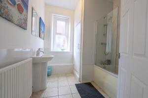 a white bathroom with a sink and a shower at The Lytham Retreat - New! Spacious & Luxurious in Lytham St Annes +68 photos