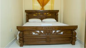 a wooden bed with two pillows in a bedroom at hotel casa martin in Gaira