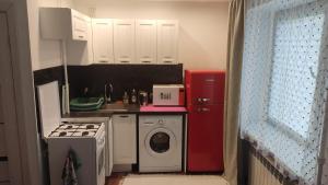 a small kitchen with a stove and a washing machine at Studio Apartment in Narva