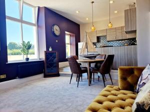 a dining room with a table and chairs and a clock at Hamilton - The Hyde Luxury Let in Preston