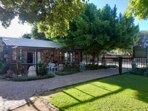 a house with a fence in front of a yard at Pumba's B&B in Sannieshof