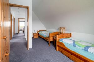 two beds in a room with a hallway at Norderhof Hansen - Ferienhaus in Nordstrand