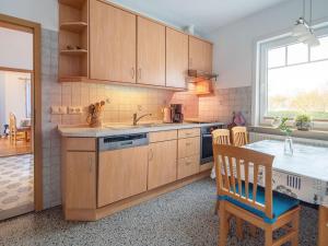 a kitchen with wooden cabinets and a table and a window at Norderhof Hansen - Ferienhaus in Nordstrand