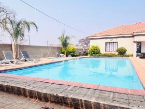 a swimming pool in front of a house at Gem Villa Inn in Lesoma