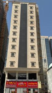un grand bâtiment au milieu d'une ville dans l'établissement فندق دفلى اثنان, à La Mecque