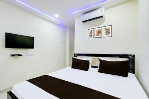 a bedroom with a white bed and a tv at HOTEL O SVR Jb Cricket ground in Pedda Ambarpet