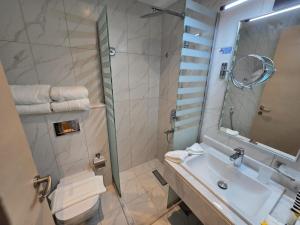 une salle de bain avec lavabo et douche dans l'établissement فندق دفلى اثنان, à La Mecque 23 autres photos