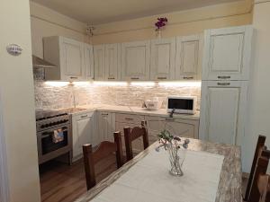 a kitchen with white cabinets and a table with chairs at Villa Finetti in Gubbio