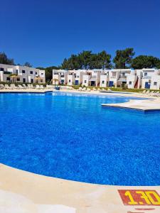a large pool with blue water in front of condos at Portimao in Bicas