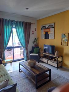 a living room with a couch and a tv at Portimao in Bicas