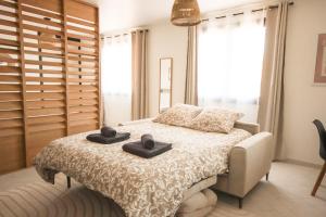 - une chambre avec un lit et 2 serviettes noires dans l'établissement Le Soy'ô - Parking - Mairie - Angoulême à 10 min, à Soyaux