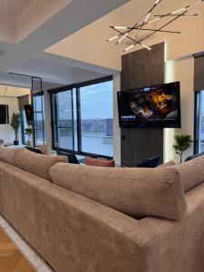a large couch in a living room with a flat screen tv at Sky View Penthouse in Craiova